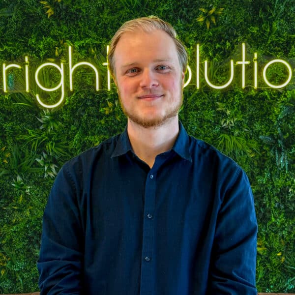 Portrait of employee in office with green wall and Bright Solutions interior