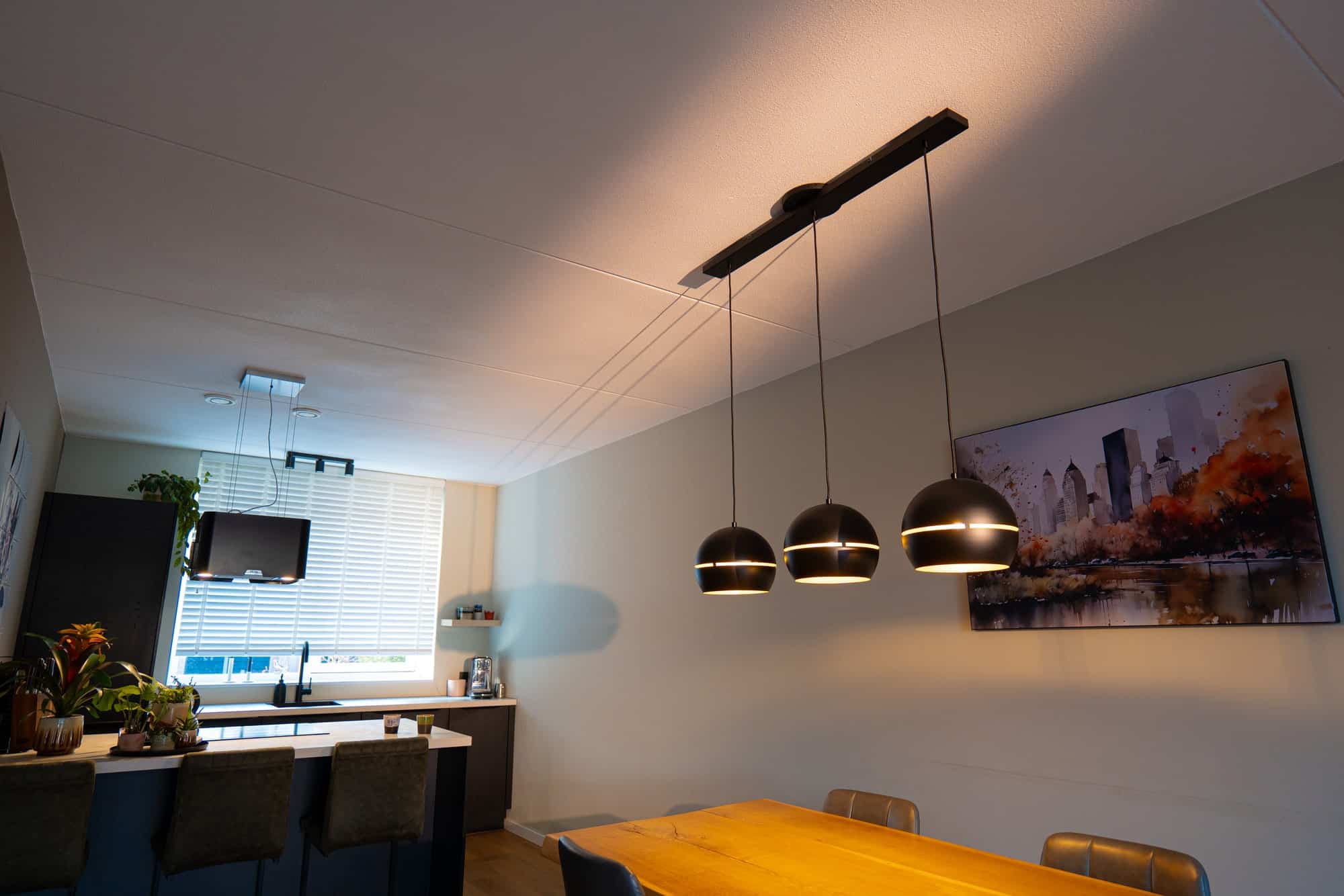 Lightswing® Zero Matt Black with three black dome pendant lights above wooden dining table in modern dining area