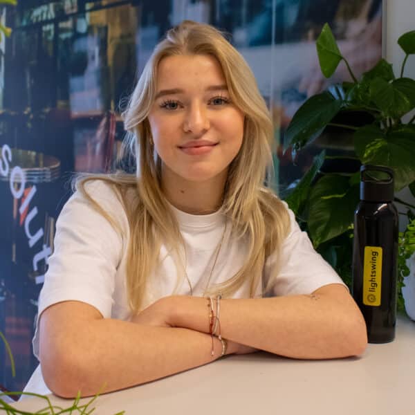 Portrait of employee in office with Bright Solutions interior and Lightswing bottle on desk